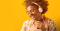 Portraits of African American young woman wearing headphones and dancing