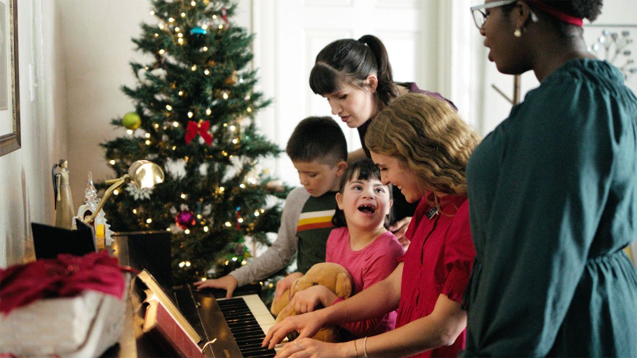 As missionárias tocam piano com uma família