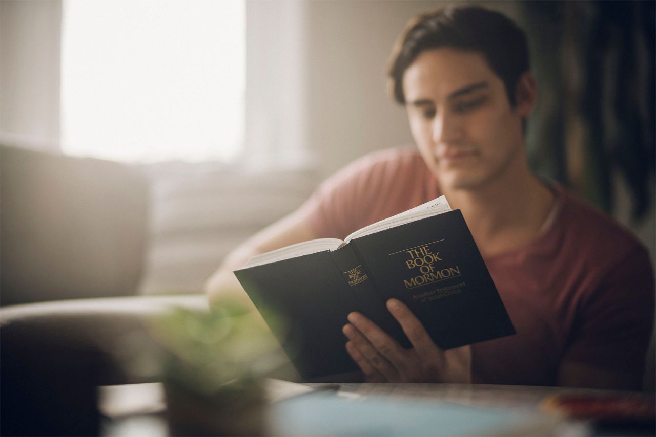 A man studies the Book of Mormon at his kitchen table
