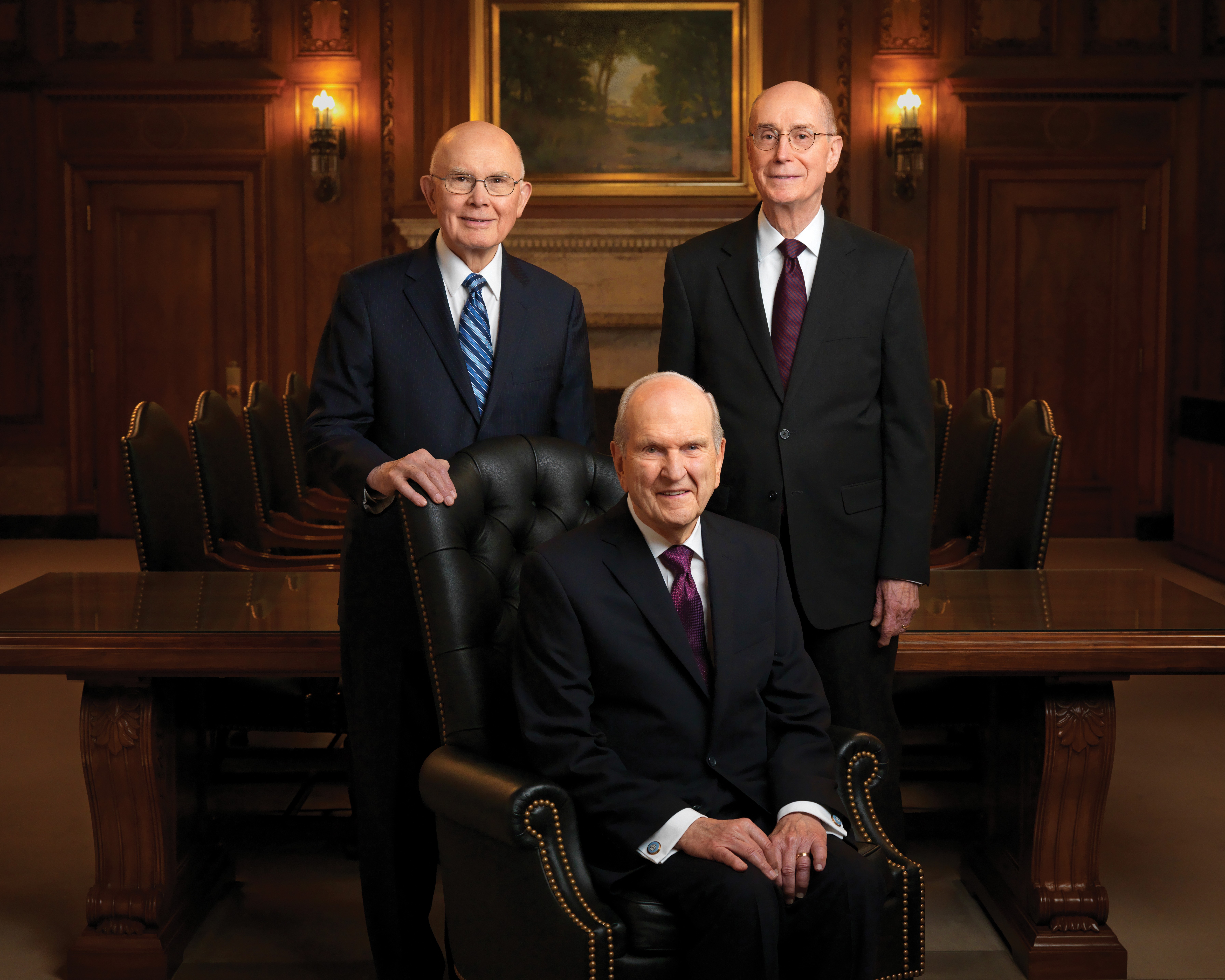 Portrait de la Première Présidence, avec Russell M. Nelson, président, assis sur un fauteuil, et ses conseillers, Dallin H. Oaks et Henry B. Eyring, debout derrière lui.