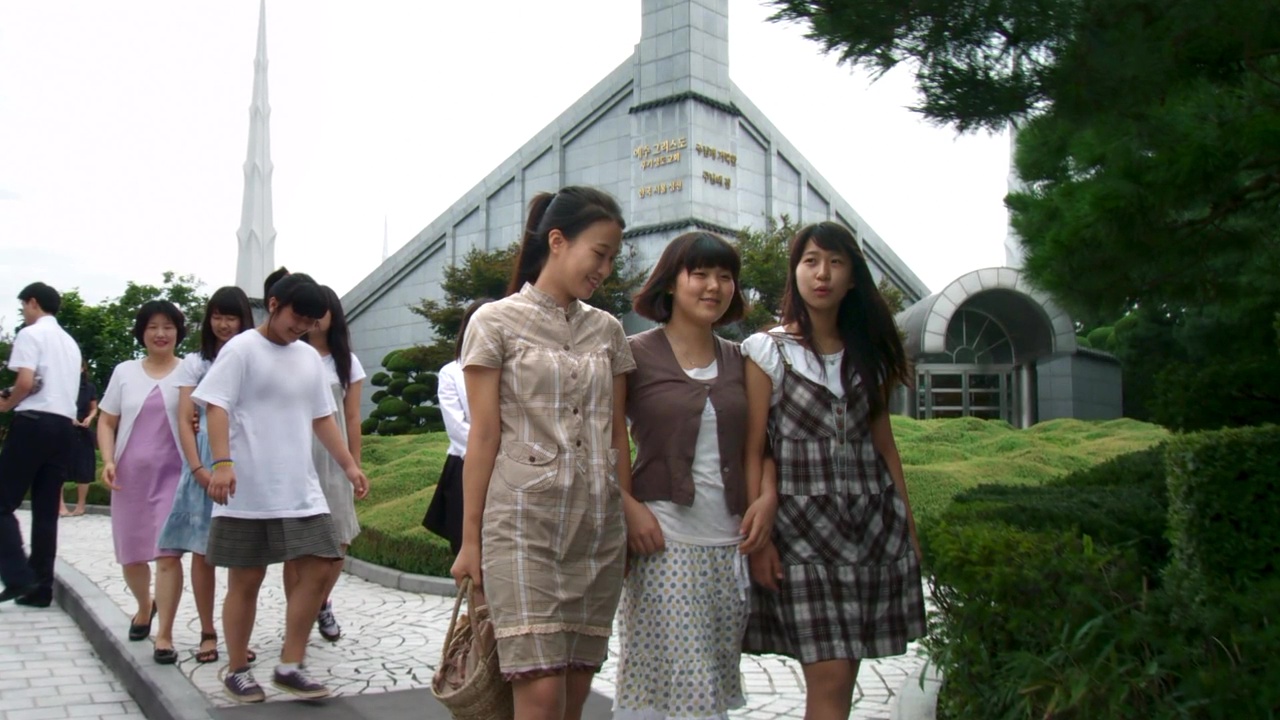 A group of teenagers walk around a temple