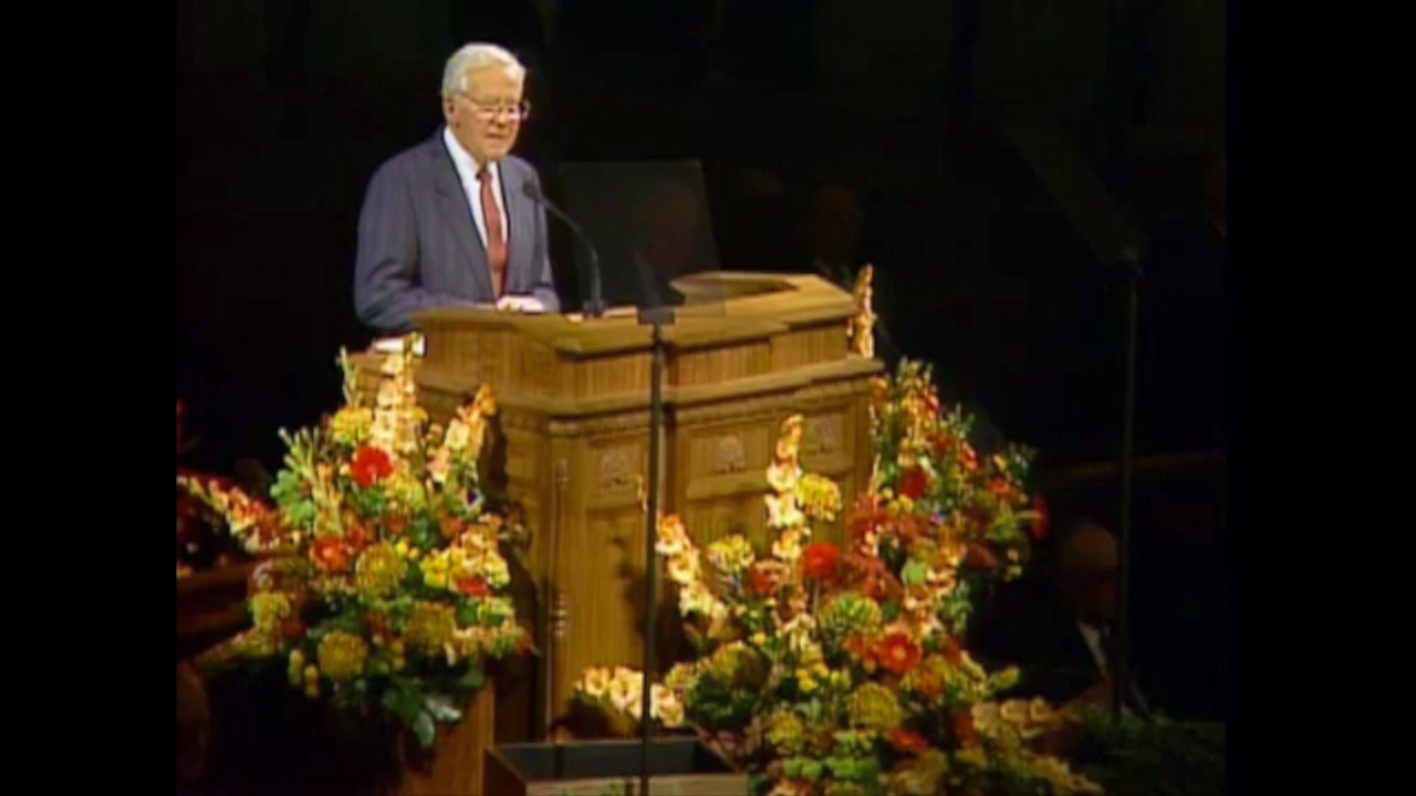 A photo of Elder Marvin J. Ashton standing at the pulpit in the General Conference Center.
