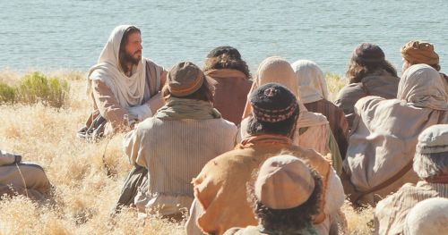 耶稣坐在人群中，耶稣在较远处，群众在较近处。