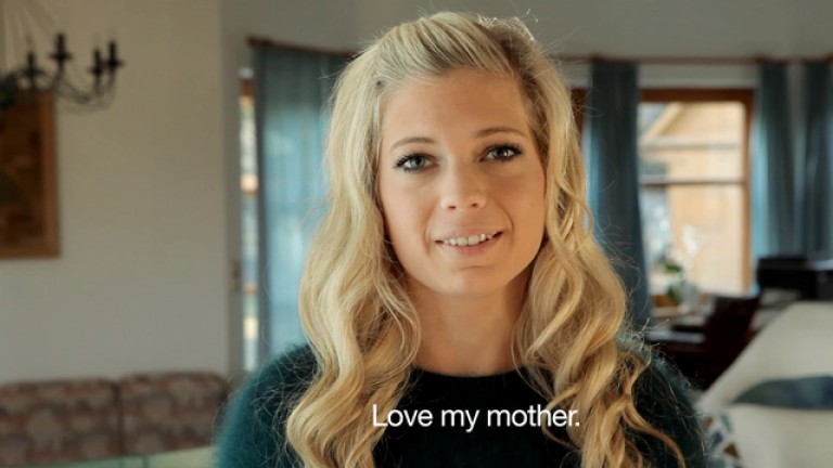 A woman smiles at the camera with the text below "Love my mother"