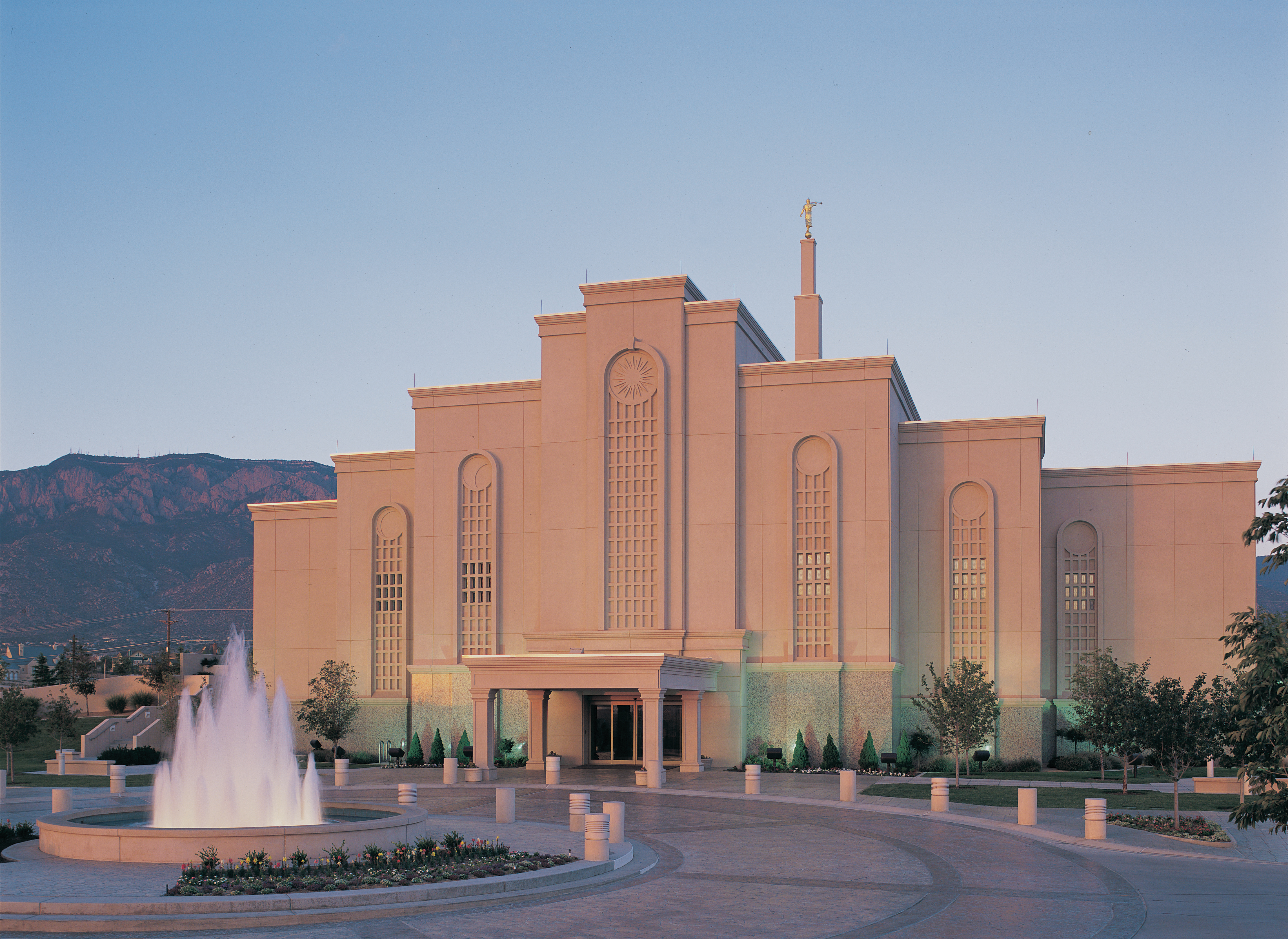A view from the front of the Albuquerque New Mexico Temple and the water fountain in the early evening, just after the lights have come on.