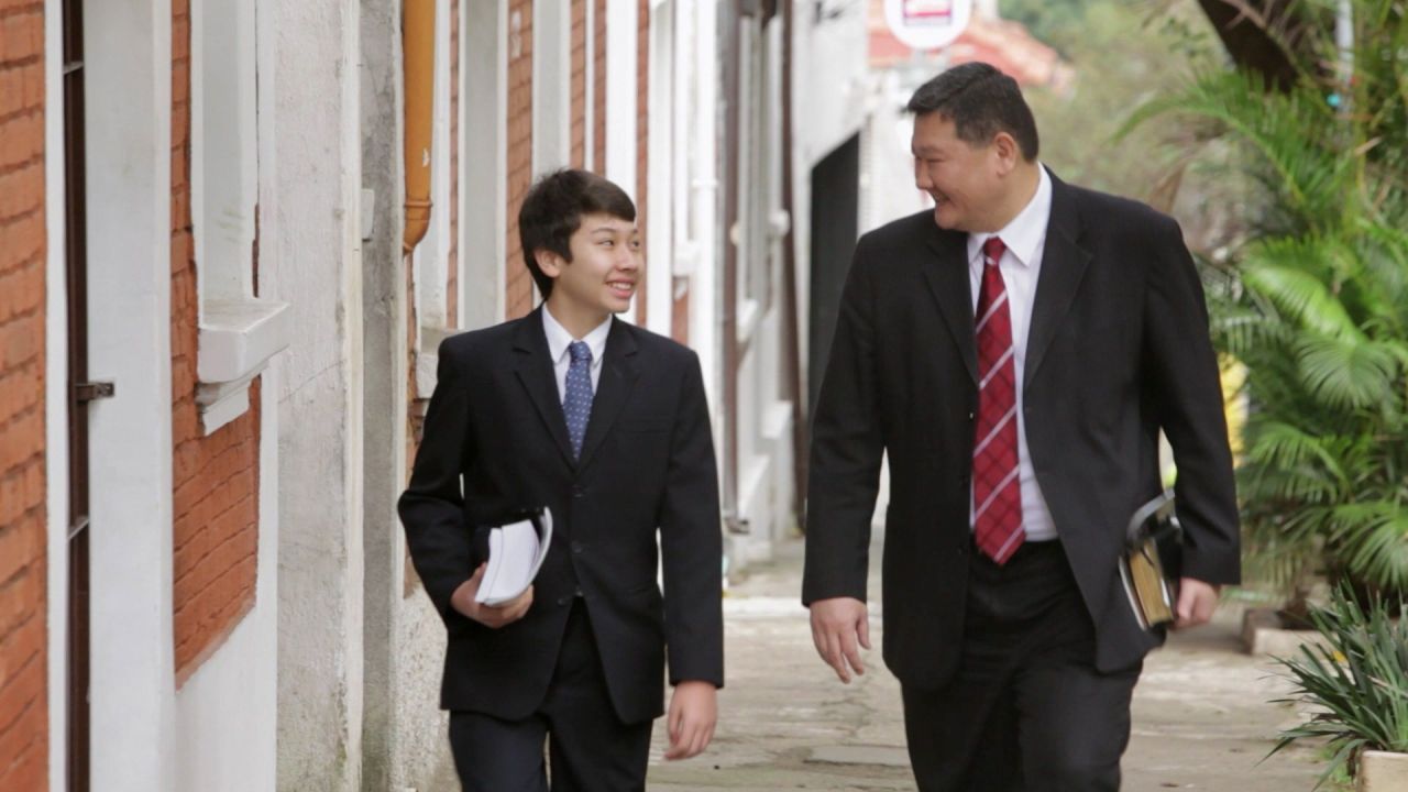Dois homens caminham pela rua compartilhando o evangelho de Jesus Cristo com outras pessoas