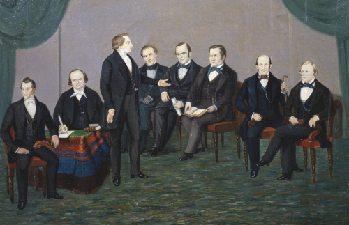 One oil on canvas painting.  Depicted in primitive style; Joseph Smith stands surrounded by seated figures of Hyrum Smith, Willard Richards, Orson Pratt, Parley P. Pratt, Orson Hyde, Heber C. Kimball and Brigham Young. Painted by William Major in Nauvoo.  Unsigned/undated.