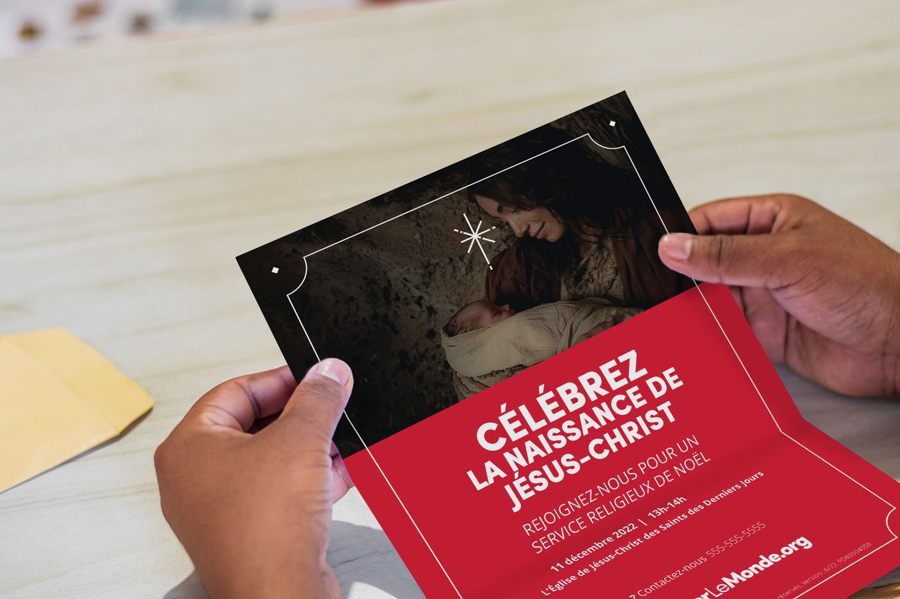 Des mains tenant une invitation pour un service de Noël
