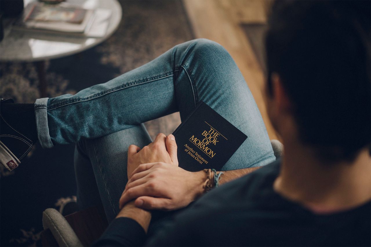 Un hombre tiene un Libro de Mormón en su regazo