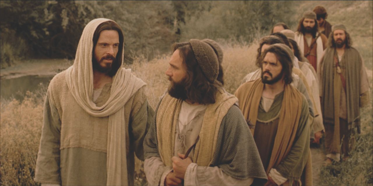 Jesucristo camina al lado de Pedro, con los otros apóstoles atras