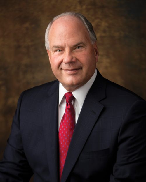 A portrait of Elder Ronald A. Rasband wearing a dark suit and red tie.