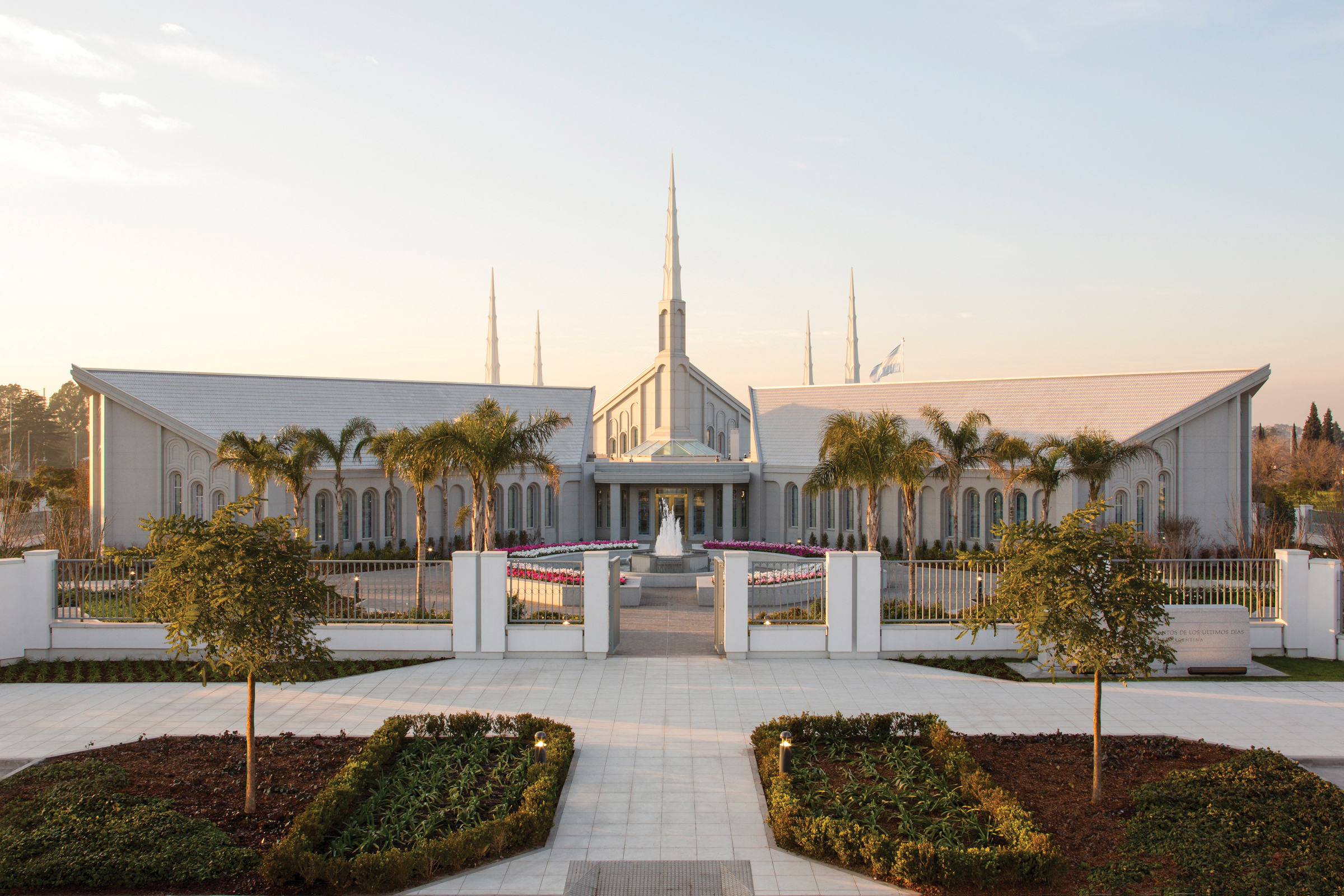 A wide-angle view from afar of the Buenos Aires Argentina Temple in the daylight, with trees and a water fountain.