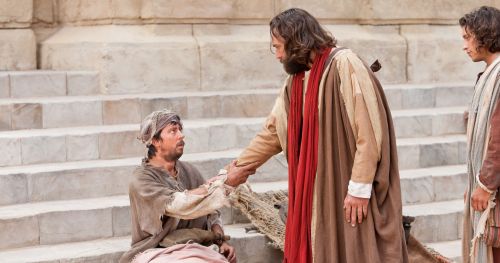 Peter reaches out his hand to a crippled man and commands him to rise and walk.