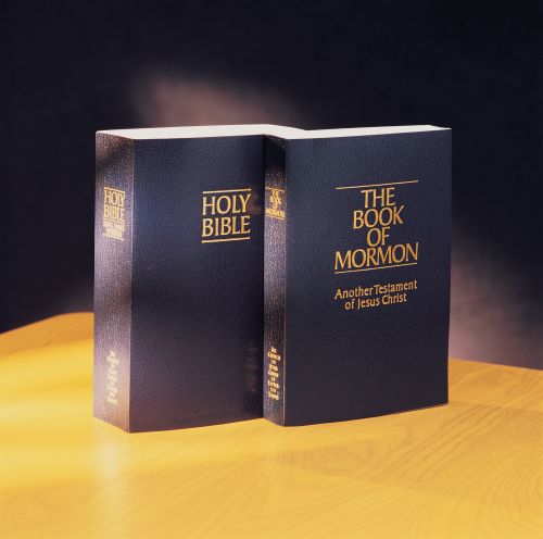 Soft-bound copies of the Bible and the Book of Mormon together on a table.