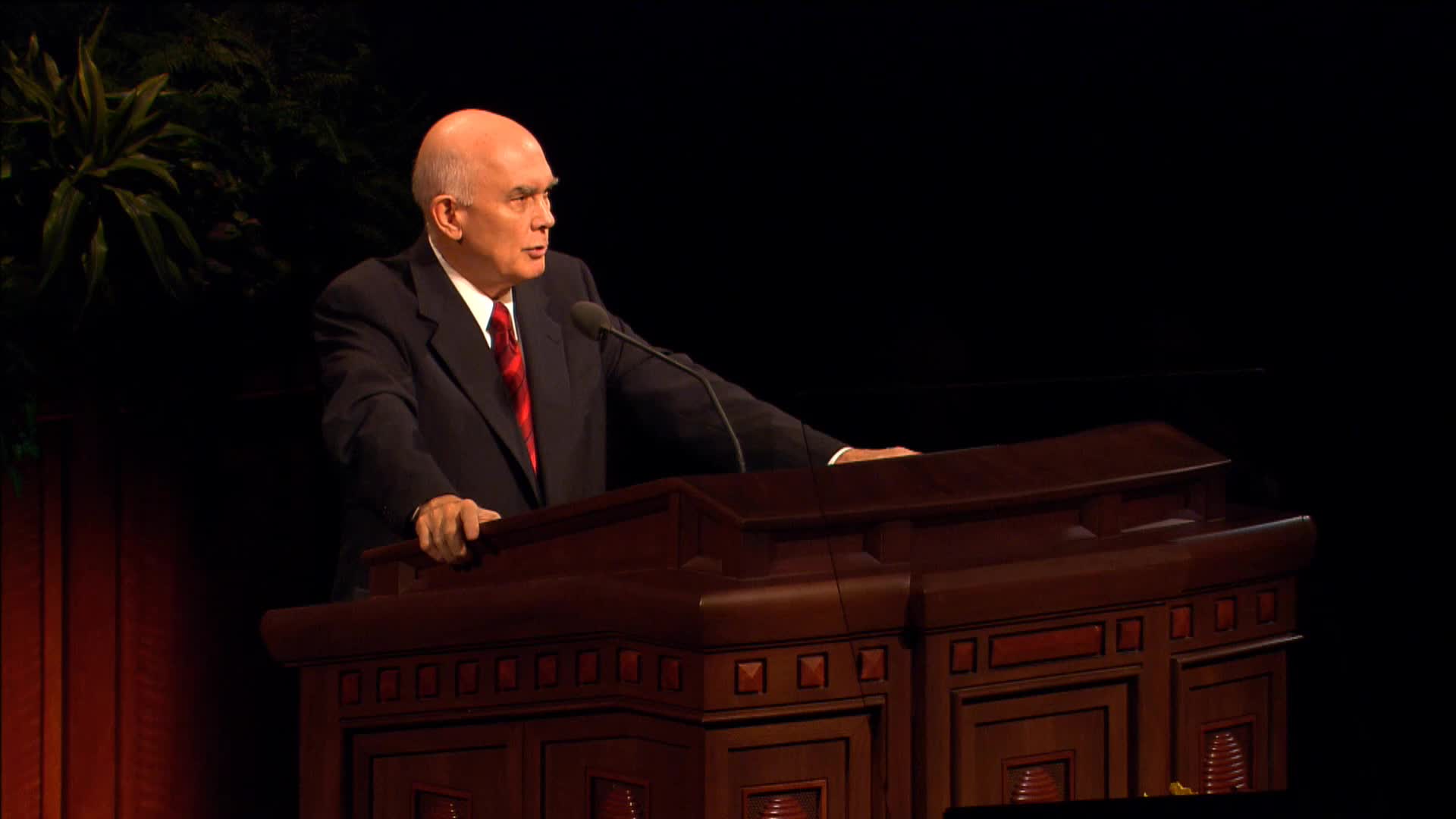 A photo of Elder Dallin H. Oaks standing at the pulpit in the General Conference Center.