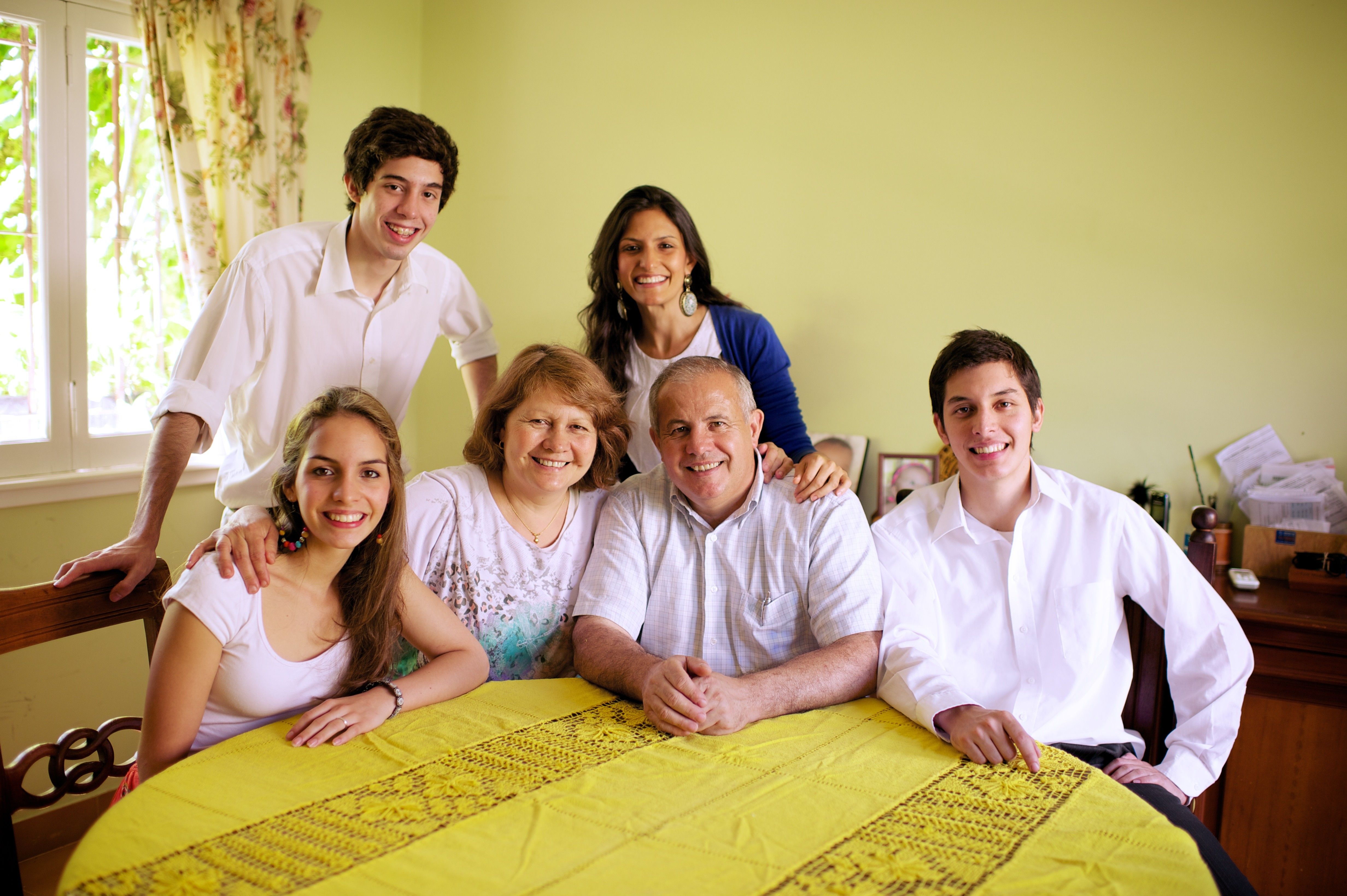 A family from Argentina sits in their home together around the dinner table.