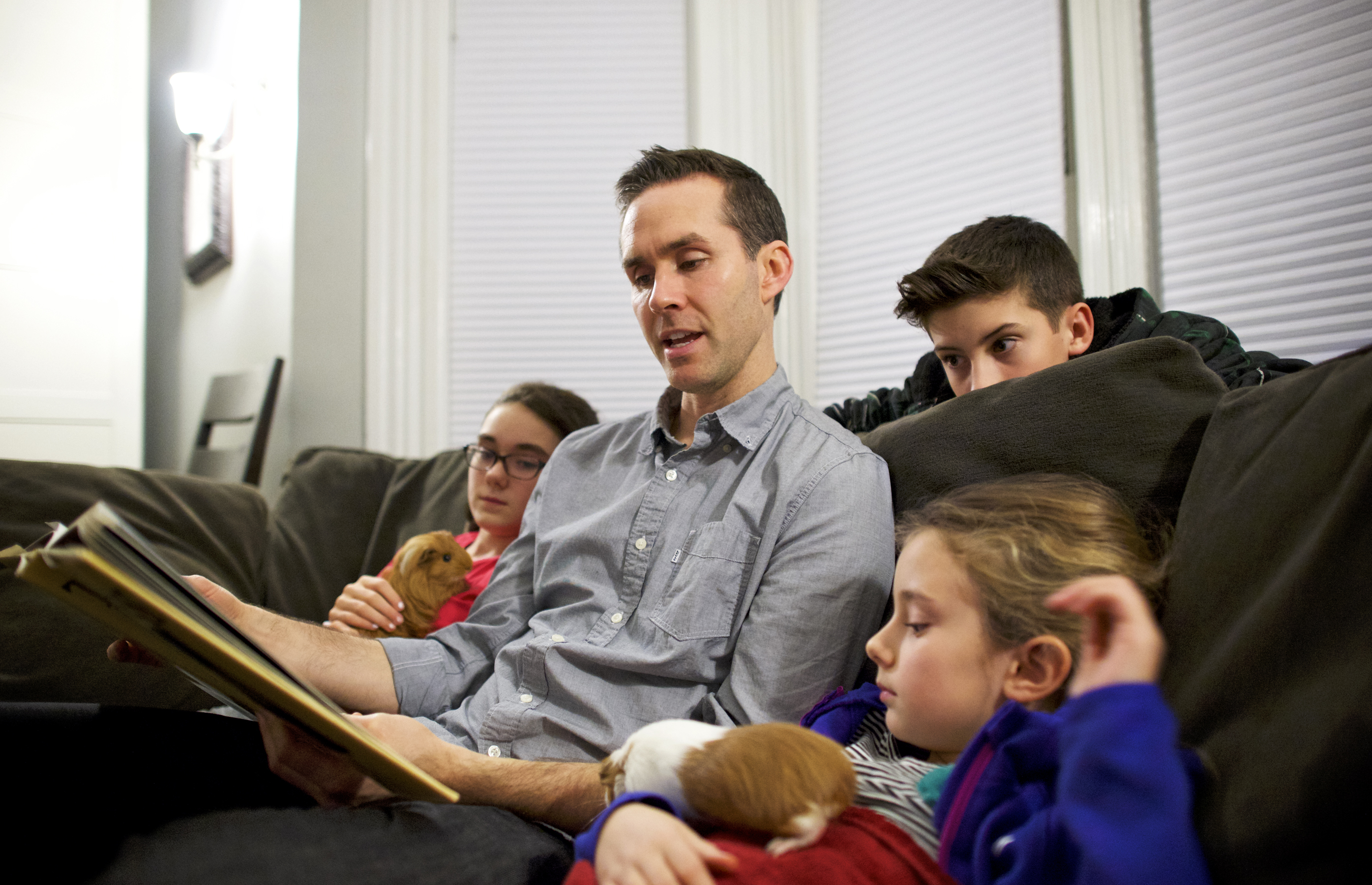 A father reads a book to his children.