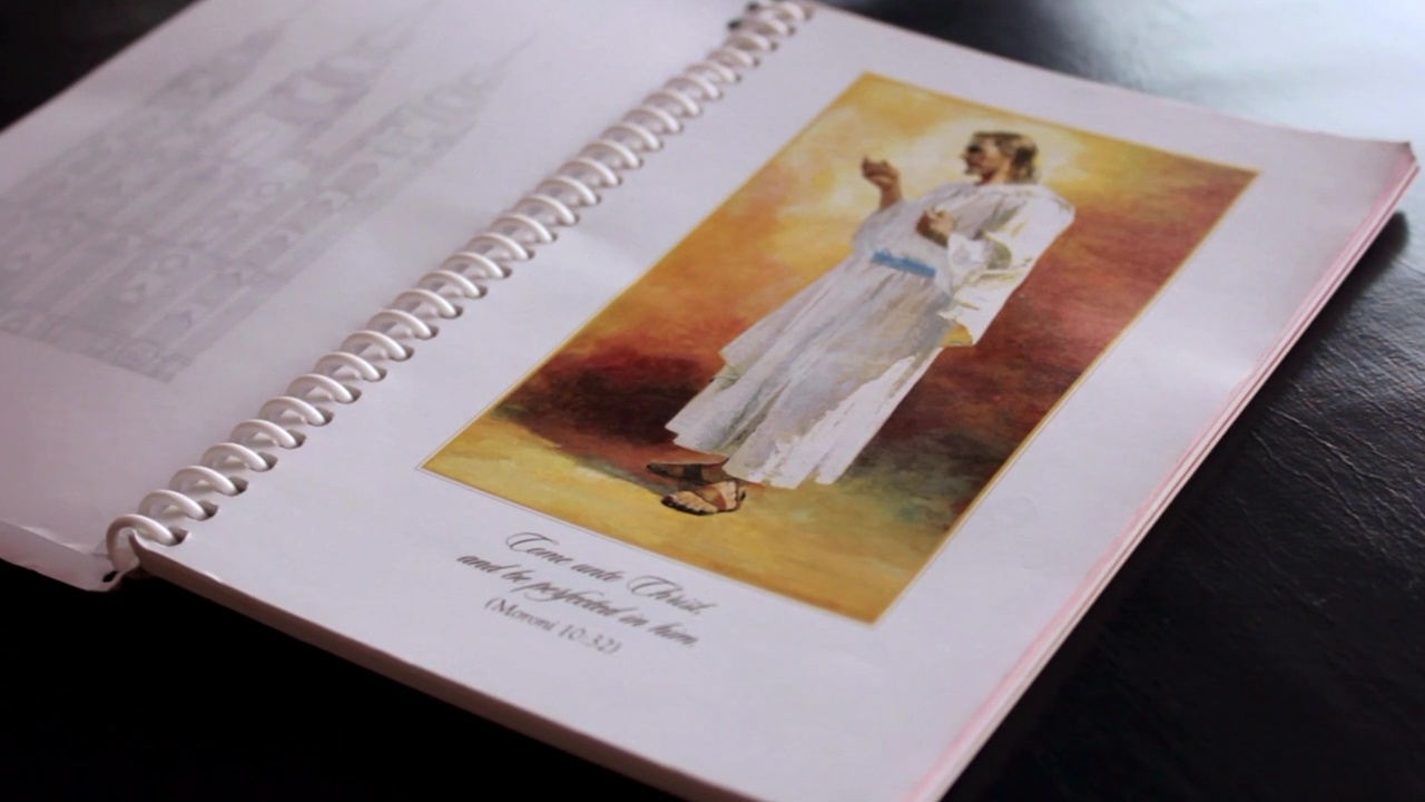 A personal progress book open to a picture of Christ