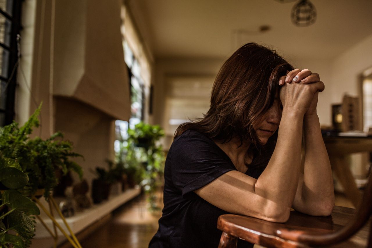 Una mujer joven se arrodilla en ferviente oración a Dios