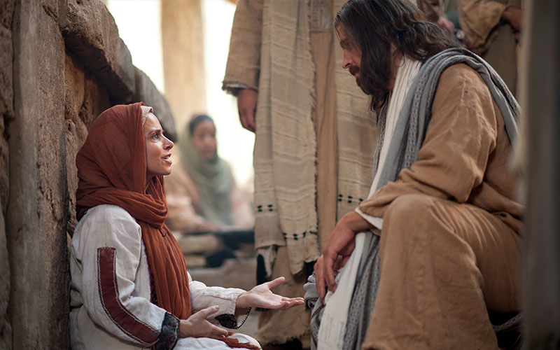 Jesus Christ speaks with a woman who through faith touched his clothes and was healed