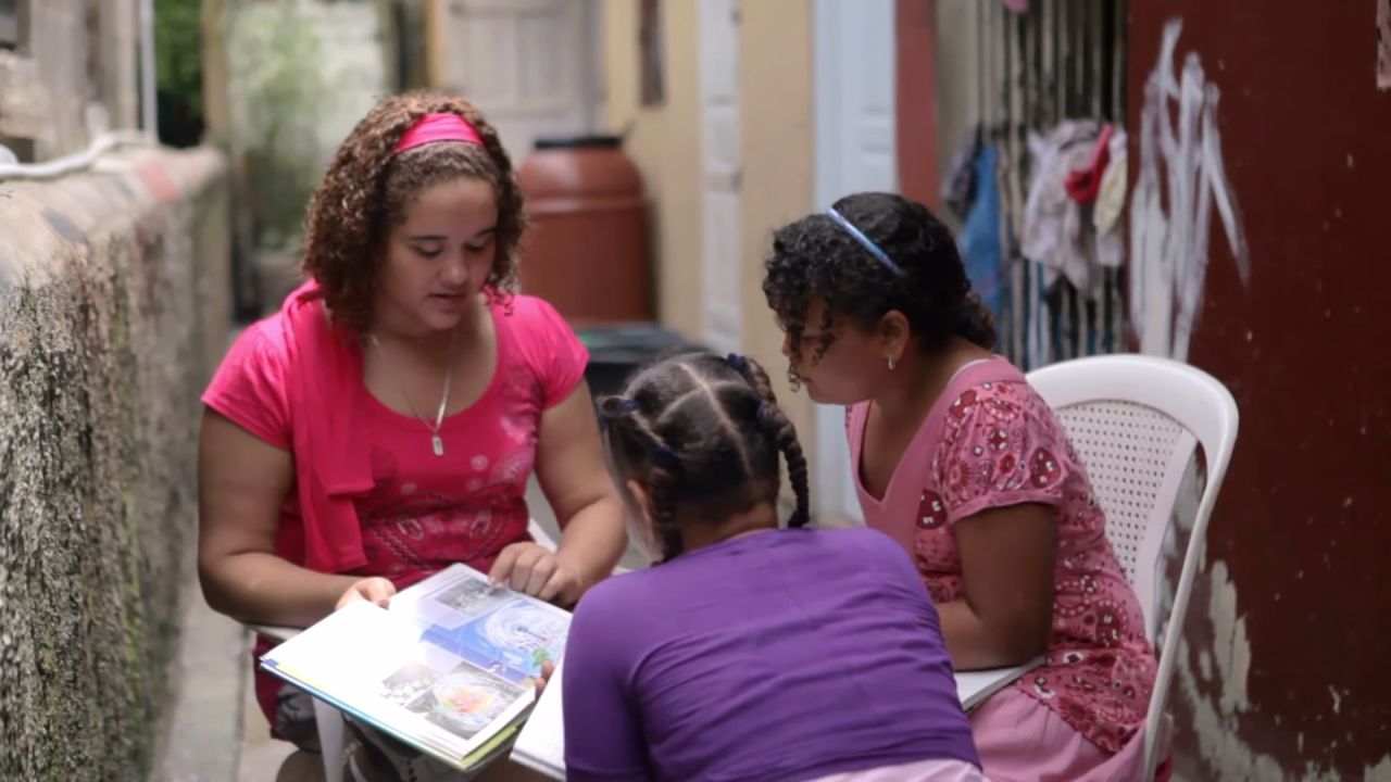 Una joven enseñando a sus hermanas menores