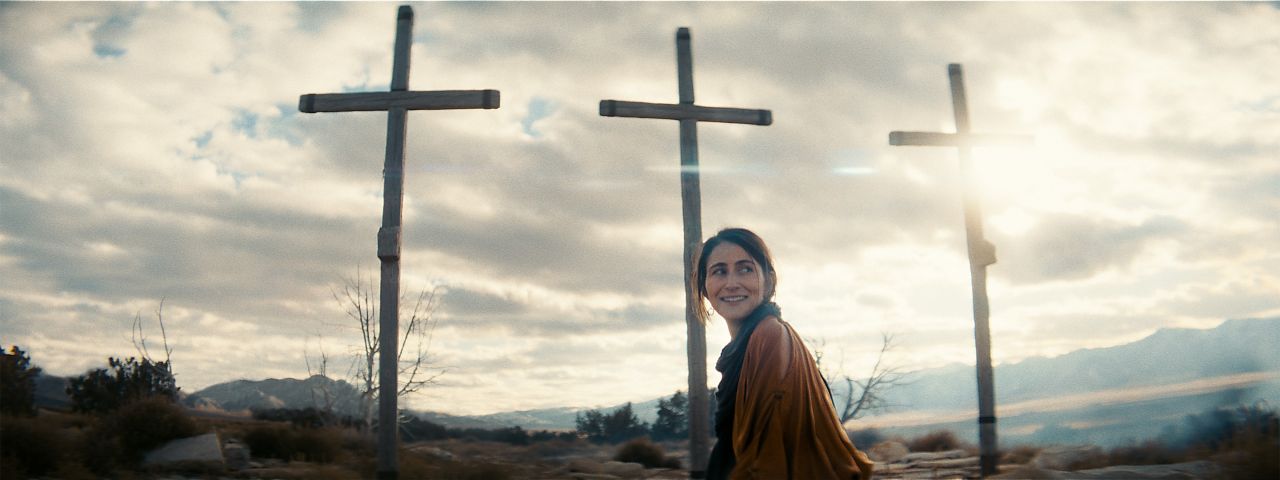 La femme marche devant trois croix