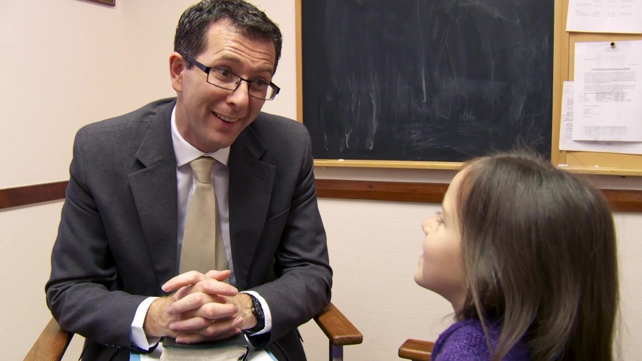 A bishop chats humorously with a primary child