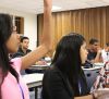 young woman raising her hand in class