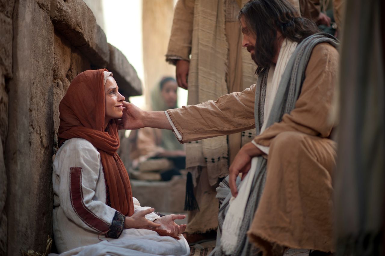 Jesus Cristo fala com uma mulher que, por meio da fé, tocou suas vestes e foi curada