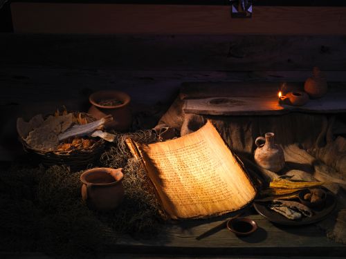 An ancient-looking handwritten document surrounded by clay pots and lamps.