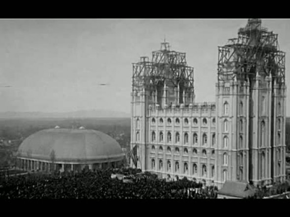 A black and white photo of the Salt Lake Temple during construction and the tabernacle.
