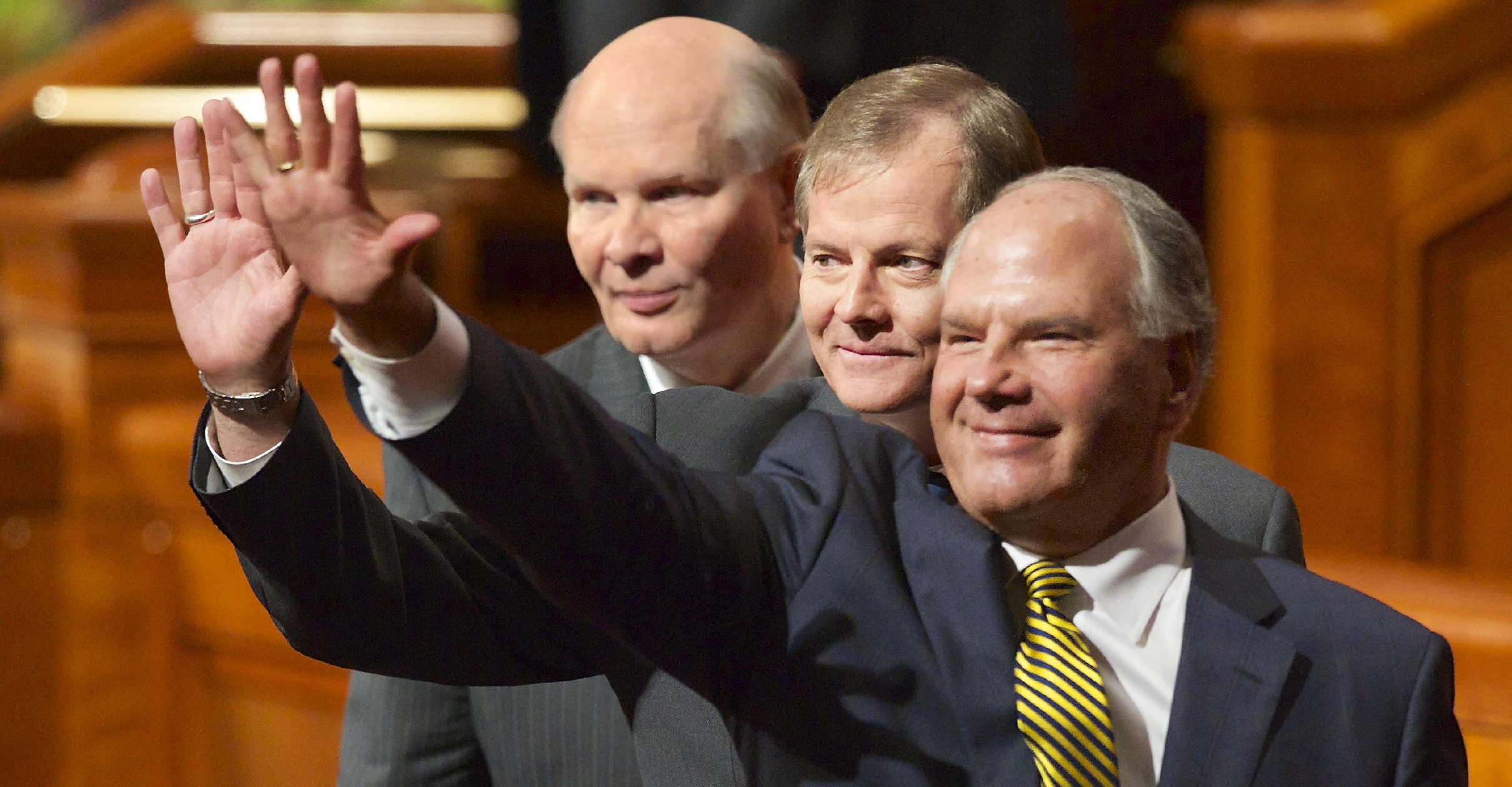 Elders Rasband, Stevenson, and Renlund waving to the congregation at a session of the October 2015 general conference as they exit the stand.