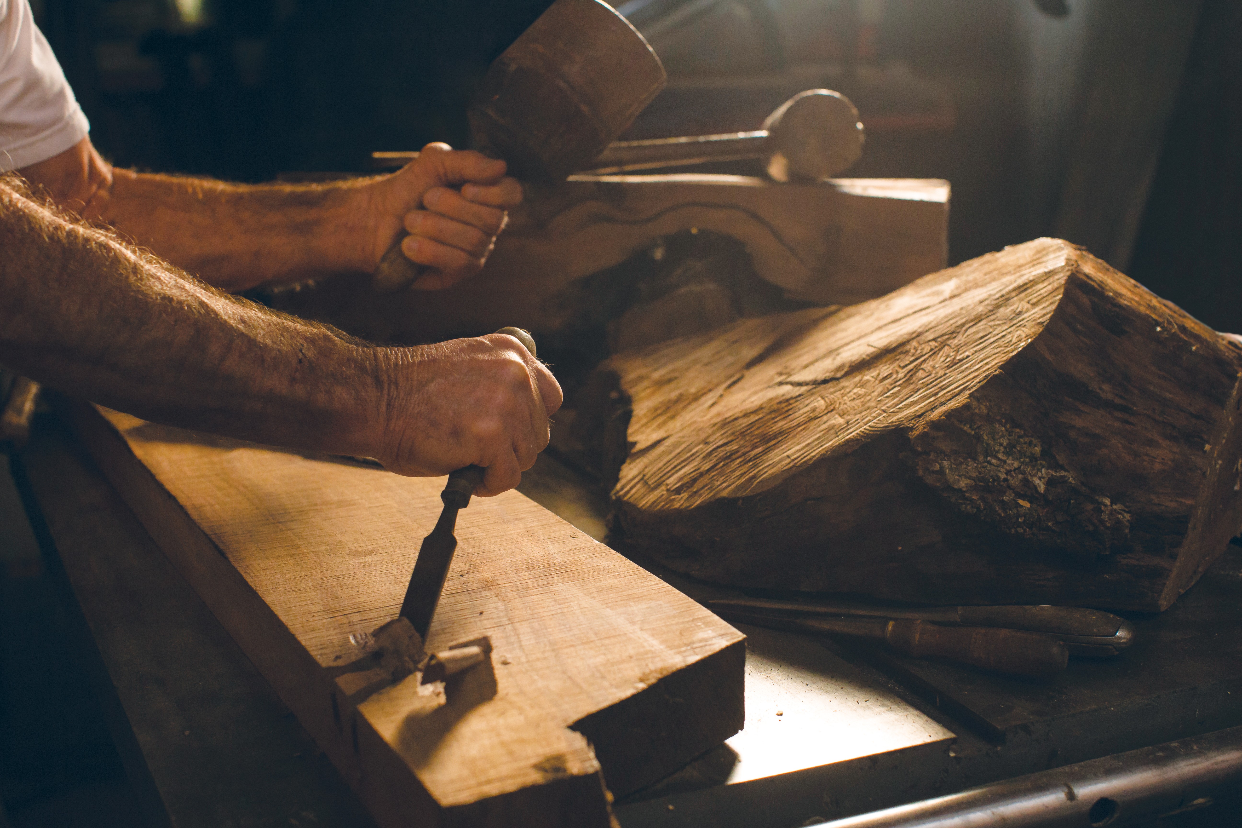 A close-up photograph of a carpenter working in his workshop.