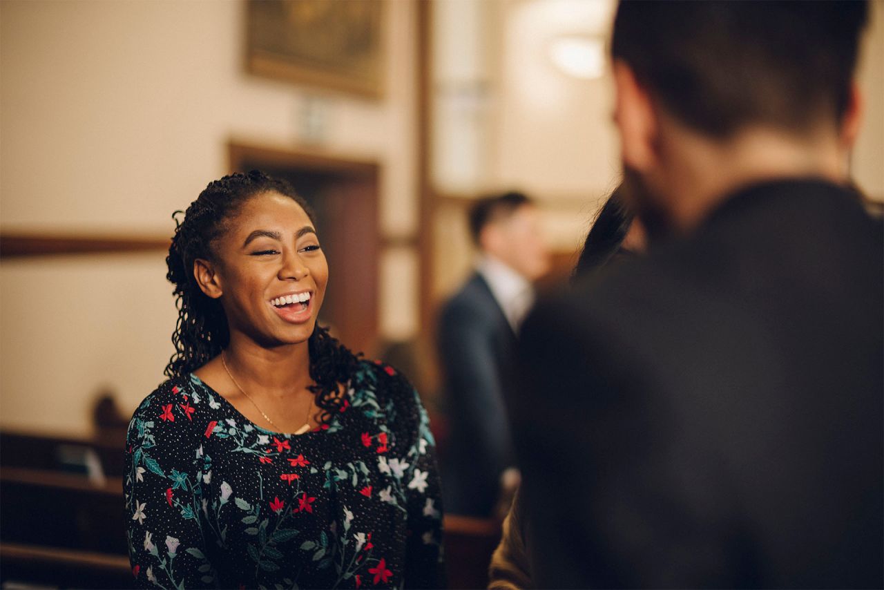 Uma mulher sorrindo fala com um homem na igreja