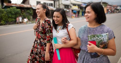 Filipino women walking on the street while visiting teaching a sister.