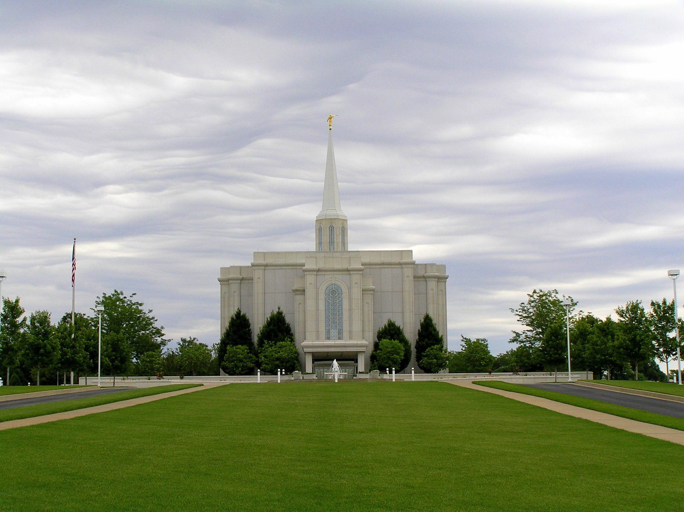 The St. Louis Missouri Temple, with a green lawn in the foreground and light gray clouds overhead.