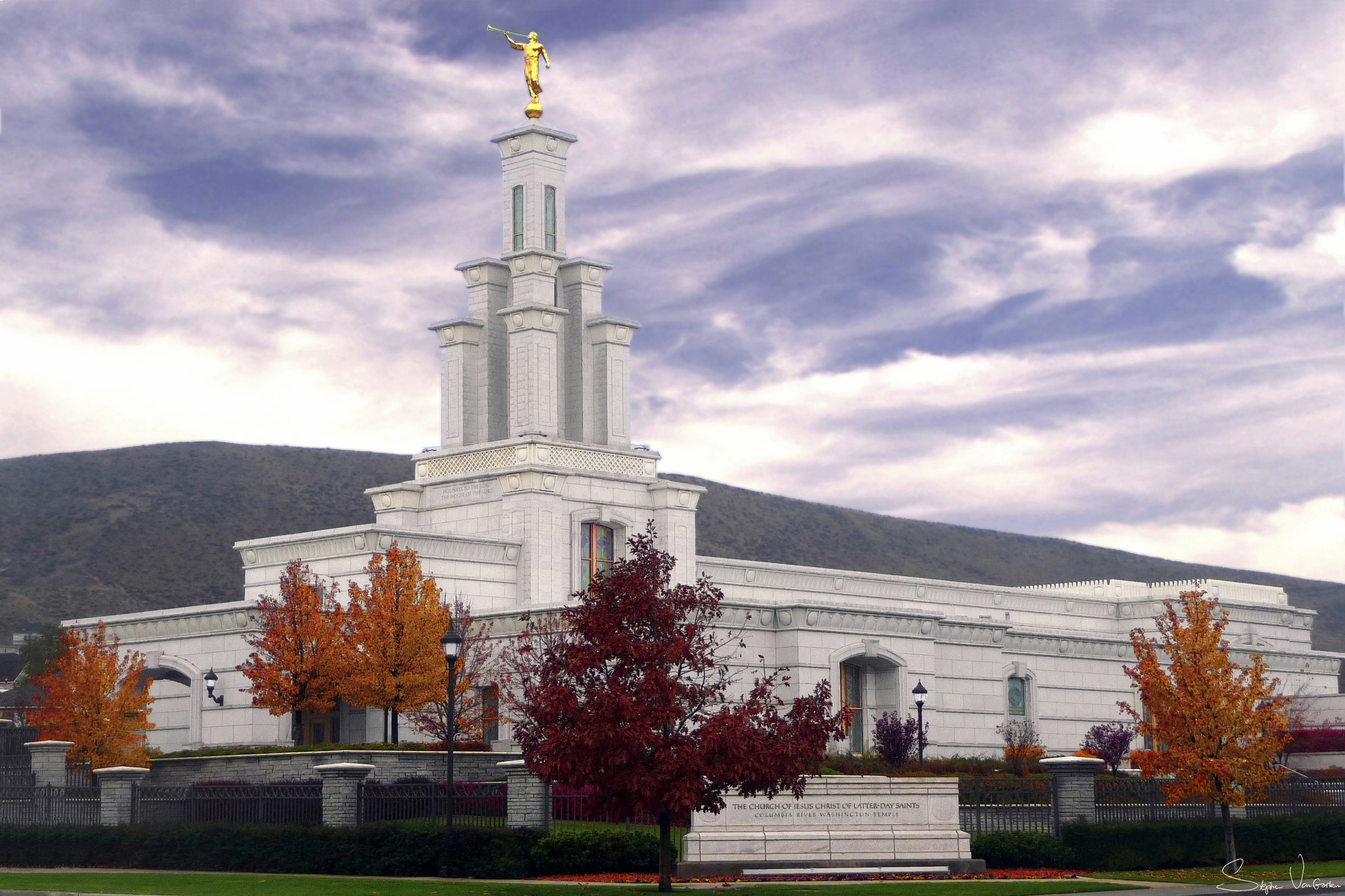 The Columbia River Washington Temple exterior on a fall day, with a hill in the background.