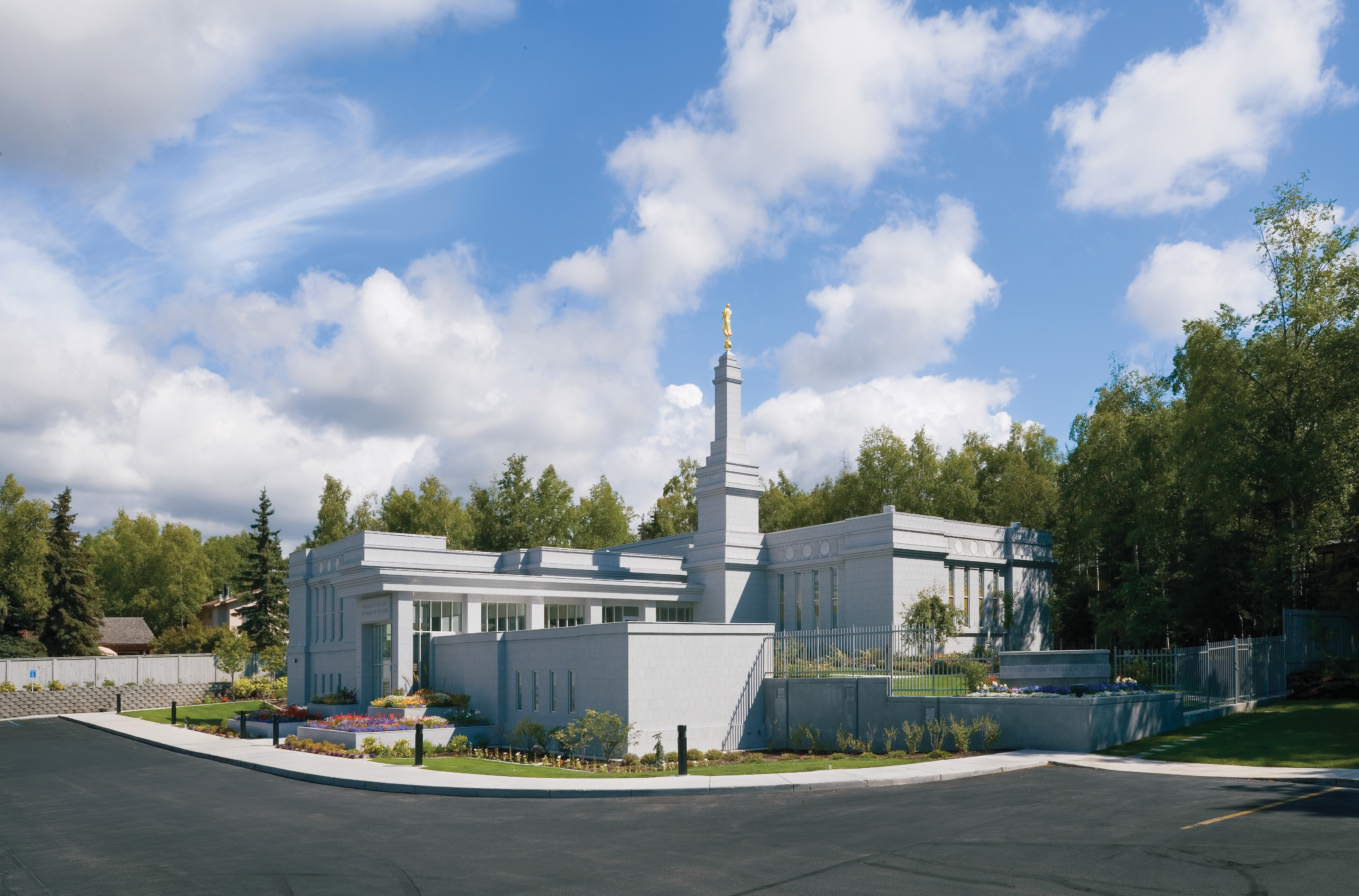A view of the whole Anchorage Alaska Temple from one of the corners, including some of the parking lot in the foreground.