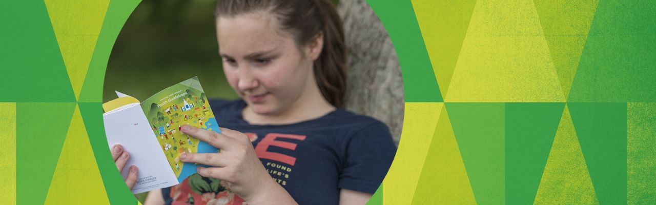 Una niña lee el folleto del programa para niños y jóvenes