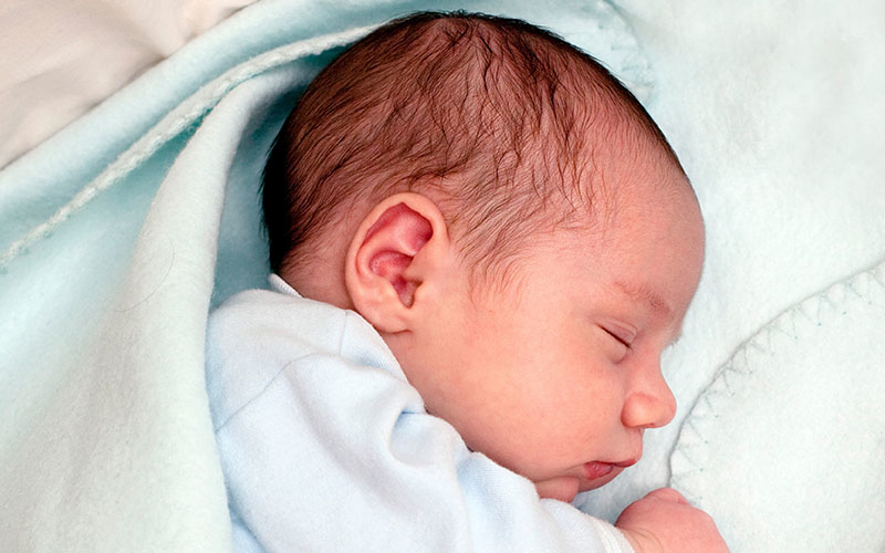 A sleeping newborn wrapped in a blanket