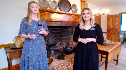 Two sister missionaries greet others in the kitchen of the Johnson home.