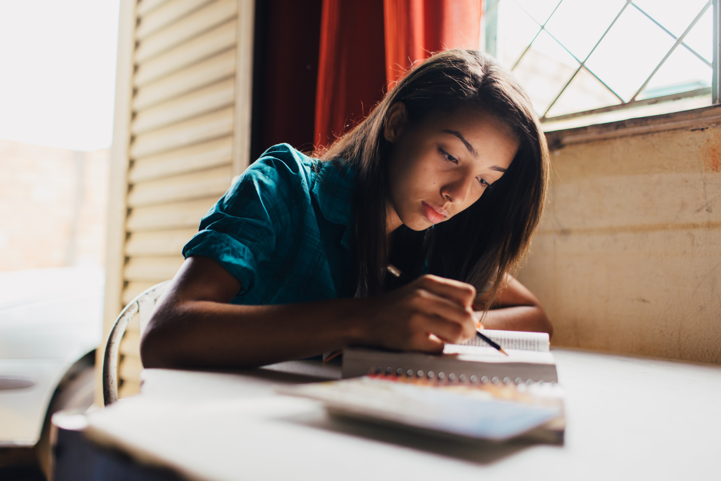 A young woman studies scriptures at a table.