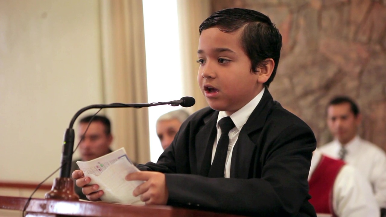A small boy speaks from the pulpit